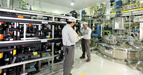 SK바이오텍 세종공장 리액팅룸에 설치된 연속반응 공정 설비(왼쪽)는 SK그룹이 유공 시절 개발한 기술을 접목한 것이다. SK바이오텍 제공