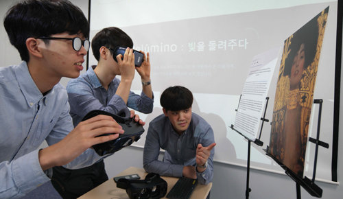 저시력 장애인들이 사물이나 글자를 좀더 뚜렷이 볼 수 있도록 보조하는 애플리케이션 ‘릴루미노’를 삼성전자 임직원들이 시연해 보이고 있다. 삼성전자 제공