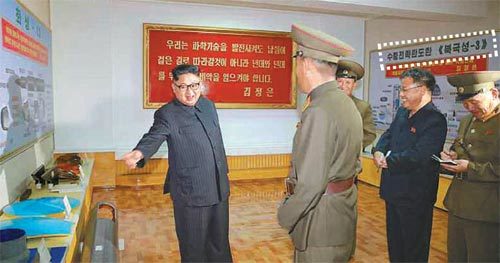 김정은 북한 노동당 위원장(왼쪽)이 대륙간탄도미사일(ICBM)급 미사일 소재를 생산하는 국방과학원 화학재료연구소를 시찰하며 웃는 
모습이 23일 공개됐다. 사진 오른쪽 벽에는 ‘수중전략탄도탄 북극성-3’이 적힌 설명판(점선 안)이, 왼쪽 벽에는 
‘화성-13’이라고 적힌 미사일 구조도가 보인다. 사진 출처 노동신문