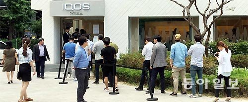 궐련형 전자담배에 담뱃세를 부과하는 방안을 두고 논란이 뜨거워지고 있다. 아이코스 구매 희망자들이 서울 종로구 직영 매장 앞에서 줄을 서서 기다리고 있다. 동아일보DB