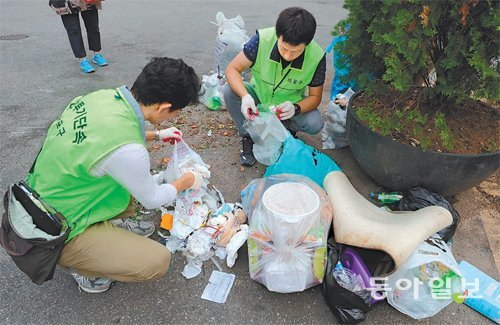 16일 서울 마포구 연남동 주택가에 버려진 불법 쓰레기봉투를 마포구 청소행정과 직원들이 뜯어보고 있다. 내용물 속에서 무단 투기자의 신원을 확인할 단서를 찾는 것이다. 장승윤 기자 tomato99@donga.com