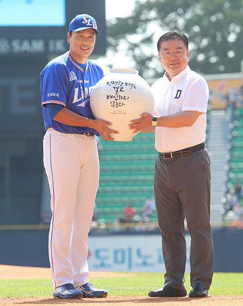 삼성 이승엽(왼쪽)이 3일 잠실구장에서 열린 5번째 ‘은퇴투어’에서 두산 김태룡 단장에게 자신의 좌우명이 새겨진 달항아리 도자기를 선물 받고 있다. 두산은 도자기를 비롯해 캐리커처와 대형 액자 등 다양한 선물을 준비했다.  사진제공｜스포츠코리아