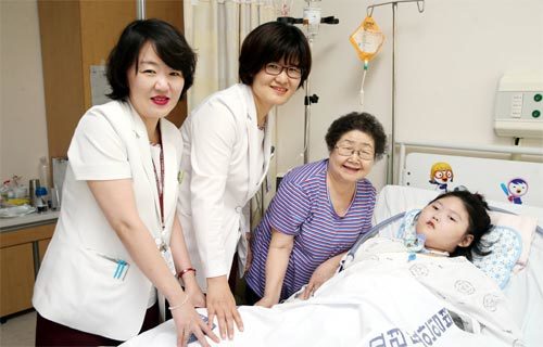 1일 서울 고려대 안암병원 간호사 정은향 씨와 이경순 씨(왼쪽에서 첫 번째와 두 번째), 이들의 기부금으로 암 수술을 무사히 마친 김인선 양(오른쪽)과 김 양의 할머니(오른쪽에서 두 번째)가 병실에서 미소 짓고 있다. 고려대 안암병원 제공