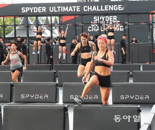 2일 서울 광화문광장에서 열린 제2회 ‘스파이더 얼티밋 챌린지’ 여성 참가자들이 턱걸이(10개) 후 장애물이 설치된 25m 코스를 뛰고 있는 모습. 안철민 기자 acm08@donga.com