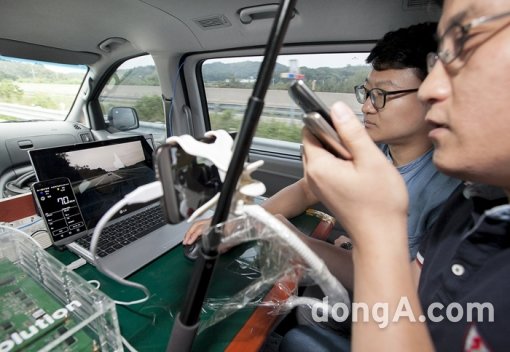 SK텔레콤과 LG전자 연구진이 LTE차량통신 기술이 탑재된 승합차 안에서 선행 차량에서 전송하는 주행 영상을 확인하고 있다. 사진제공=SK텔레콤