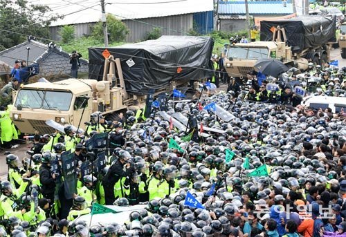 우여곡절끝 사드 배치한 南 주한미군이 7일 오전 경북 성주군 사드 기지에 잔여 발사대 4기를 반입하는 가운데 기지 인근의 소성리 마을회관 앞에서 반입을 저지하려는 시위대와 이를 막는 경찰이 한데 뒤엉켜 있다. 경찰은 이날 사드 반입로를 확보하기 위해 경비병력 8000여 명을 동원해 시위를 막았다. 성주=김재명 기자 base@donga.com