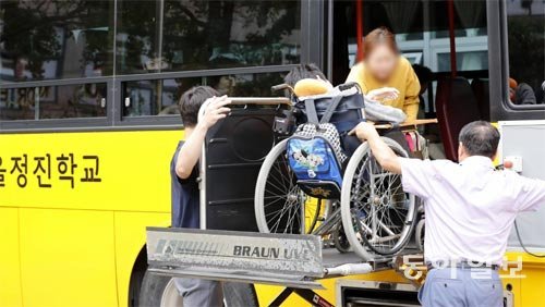 11일 오후 서울 구로구 궁동 정진학교에서 교사들이 휠체어를 탄 지체장애 학생의 스쿨버스 탑승을 돕고 있다. 이 학교엔 장거리 통학생이 많아 통학버스 7대를 운영하고 있다. 원대연 기자 yeon72@donga.com