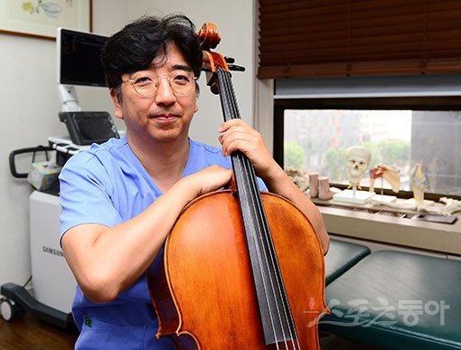 연주자들을 고치기 위해 직접 연주의 세계에 뛰어든 유재욱 원장이 병원 진료실에서 자신의 첼로를 안고 포즈를 취했다. 김진환 기자 kwangshin00@donga.com