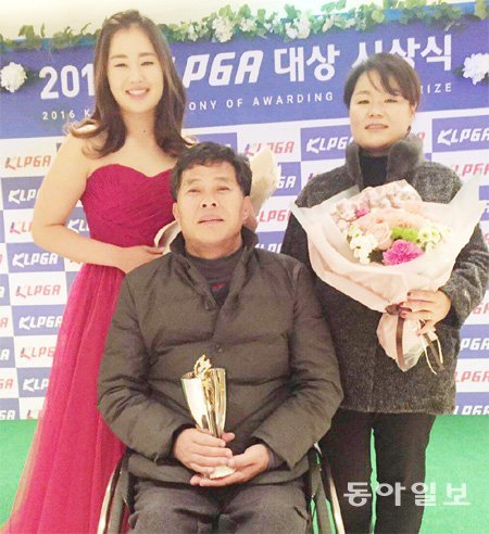 이정은(왼쪽)이 지난해 말 열린 한국여자프로골프(KLPGA)투어 시상식에서 신인상을 받은 뒤 휠체어를 탄 아버지 이정호 씨, 어머니 주은진 씨와 기념촬영을 하고 있다. 동아일보DB