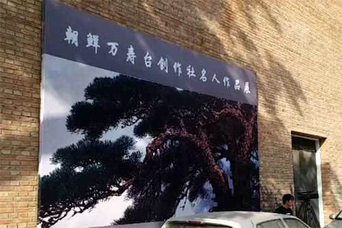 중국 베이징 798 예술구에 있는 만수대창작사 전시관 외벽에 ‘조선만수대창작사명인작품전’이라 쓰여 있는 패널이 걸려 있다.