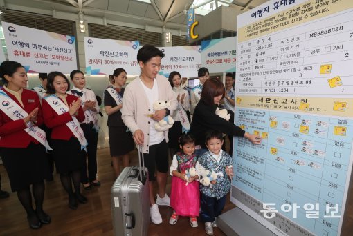 인천본부세관이 올 추석 열흘간의 황금연휴를 앞둔 27일 인천국제공항 출국장에서 여행자 휴대품 성실신고 캠페인을 개최했다. 이날 캠페인에서 관계자들이 대형 세관신고서에 성실신고 다짐 스티커를 붙이는 퍼포먼스를 하고 있다.