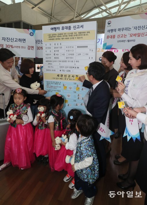 인천본부세관이 올 추석 열흘간의 황금연휴를 앞둔 27일 인천국제공항 출국장에서 여행자 휴대품 성실신고 캠페인을 개최했다. 이날 캠페인에서 관계자들이 대형 세관신고서에 성실신고 다짐 스티커를 붙이는 퍼포먼스를 하고 있다.