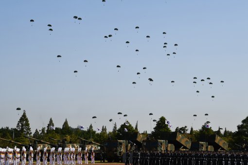 28일 경기도 평택 해군 제2함대 사령부에서 열린 국군의 날 행사에 국군의 최신 무기들이 도열해 있는 가운데 특전사 장병들이 강하시범을 보이고 있다. 국군의날 행사가 해군기지에서 열리는 것은 창군 이후 처음이다. 이번 행사에선 우리 군의 북한 타격용 무기들을 대거 공개했다.2017.09.28