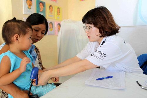 인하대병원 공공의료사업지원단 의료진이 19일 필리핀 수도 마닐라에서 북서쪽으로 약 250㎞ 떨어진 삼발레스주(州) 마신록시(市) 산 로렌소 바랑가이 마을에서 어린이를 진료하고 있다. 포스코건설 제공