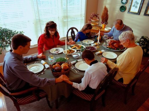 추수감사절 식탁에서 가족들이 감사의 기도를 하는 모습
