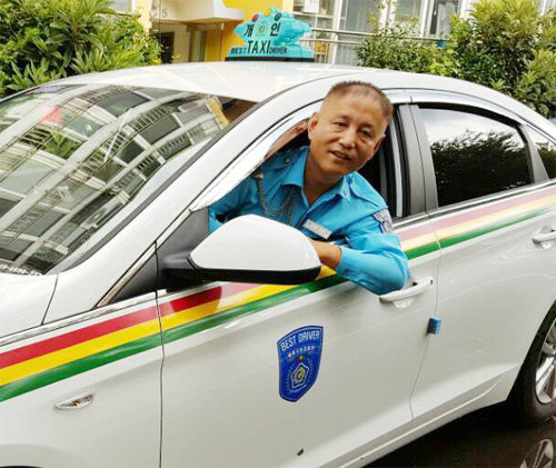 제주에서 13년째 홀몸노인 반찬 배달 봉사를 하고 있는 송수빈 씨가 자신의 택시에 앉아 웃고 있다. 송 씨는 “명절에 특히 외로울 어르신들을 위해 조금씩이라도 나눔을 실천하면 좋겠다”고 말했다. 초록우산 어린이재단 제공