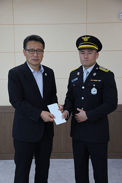 ‘소방관 파이터’ 신동국(사진 오른쪽)이 9월 29일 고(故) 이영욱 소방경과 고(故) 이호현 소방교가 근무했던 강릉 소방서를 방문해 파이트머니 전액을 전달했다. 사진제공 ｜ 로드FC