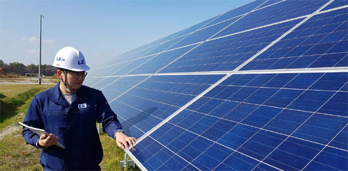 LS산전이 한국전력과 함께 만든 일본 지토세 태양광발전소가 26일 준공됐다. LS산전 관계자가 태양광 모듈을 점검하는 모습. LS그룹 제공