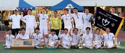 동아일보 선수단이 28일 경기 고양시 어울림누리 별무리구장에서 막을 내린 제45회 한국기자협회 서울지역축구대회에서 2연패를 달성한 뒤 우승 트로피와 우승기를 들고 환호하고 있다. 동아일보는 1972년, 2011년, 2016년에 이어 통산 4번째 정상에 올랐다. 고양=변영욱 기자 cut@donga.com