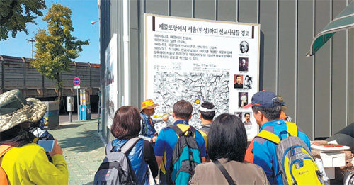 인천지법산악회원들이 지난달 21일 중구 항동1가 한국기독교100주년기념탑 앞에서 선교사 이동경로 안내판을 보며 해설사 설명을 듣고 있다. 여기는 인천둘레길 12구간 성창포길이다. 인천지방법원산악회 제공