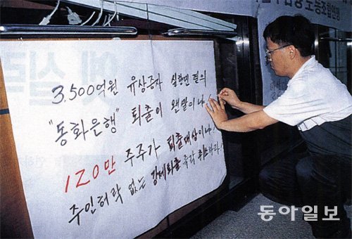 5개 은행 퇴출 소식이 알려진 1998년 6월 29일 동화은행 노조원이 퇴출 결정에 반대하는 내용의 대자보를 당시 서울 세종로 본점 농성장에 붙이고 있다. 동아일보DB