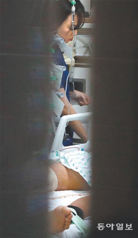 문틈으로 보이는 北병사 다리 14일 0시경 경기 수원시 아주대병원 외상센터 문틈으로 전날 귀순한 북한군
 하전사의 한쪽 발과 다리 일부가 보인다. 이 병사는 7군데 이상의 내장 파열이 발견돼 이 시간까지 수술을 받았으나 의식을 
회복하지 못했다. 링거에 적인 이름은 ‘무명남’. 수원=전영한 기자 scoopjyh@donga.com