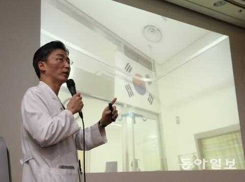 귀순병 병실의 태극기 귀순 도중 총상을 입은 북한 병사의 주치의인 이국종 아주대병원 권역외상센터장이 22일 병실에 걸린 태극기 사진을 보여주며 환자 상태를 설명하고 있다. 박영대 기자 sannae@donga.com