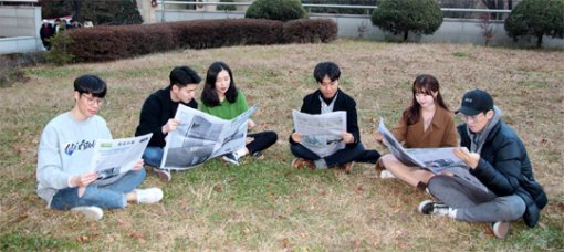 28일 서울 광진구 세종대 광개토관 앞 잔디밭에서 학생들이 청년드림대학 평가 결과를 소개한 동아일보를 펼쳐보며 이야기를 나누고 있다. 세종대 제공