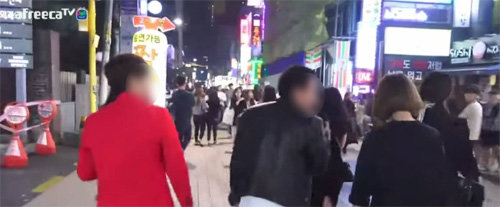 남성 BJ(가운데)가 서울 강남역에서 길 가던 여성에게 말을 걸고 있다. 최근 젊은이가 많이 찾는 번화가를 무대로 이른바 거리방송을 생중계하는 사례가 늘면서 상인들과 마찰까지 빚고 있다. 유튜브 화면 캡처