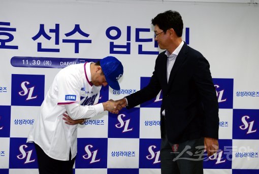 30일 대구 라이온즈파크에서 4년 총액 80억에 FA 계약한 삼성 강민호의 입단식이 열렸다. 강민호가 김한수 감독으로부터 모자를 받은 뒤 악수를 나누고 있다. 대구 | 김민성 기자 marineboy@donga.com