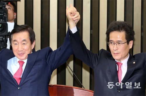 12일 의원총회에서 새 원내대표로 당선된 자유한국당 김성태 의원(왼쪽)이 함진규 신임 정책위의장과 함께 손을 들어 소속 의원들에게 인사하고 있다. 김동주 기자 zoo@donga.com