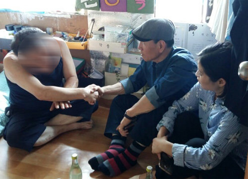 “술, 끊을수 있습니다” 서울시정신건강센터 소속 회복자상담가(오른쪽 두 명)들이 알코올의존증 환자의 집을 찾아가 손을 잡으며 상담하고 있다. 센터의 회복자상담가 16명은 모두 알코올의존증 치료를 받은 사람들로 환자들이 술을 끊을 수 있도록 돕고 있다. 서울시정신건강센터 제공