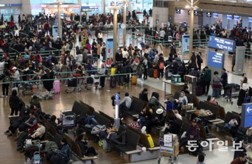 사진=24일 오전 짙은 안개로 비행기 이착륙이 지연된 인천국제공항 출국장에 여행객들이 수시간 째 지친 모습으로 탑승수속을 기다리고 있다. 양회성 기자 yohan@donga.com