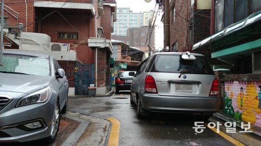 24일 서울 강동구 주택가 이면도로 상당 부분을 불법 주정차 차량들이 차지했다. 차량이 다닐 수 있는 도로 폭이 채 5m가 되지 않는다. 서형석 기자 skytree08@donga.com