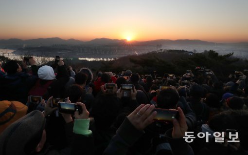 서울에서 가장 먼저 해가 뜬다는 광진구 아차산에서 시민들이 떠오르는 해를 바라보며 휴대폰으로 사진을 찍고 있다. 박영대 기자 sannae@donga.com