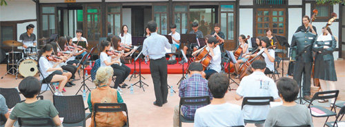 지난해 7월 개장한 공주시 구도심 제민천변의 하숙마을. 개장을 기념하는 청소년오케스트라 연주가 펼쳐지고 있다. 공주시 제공
