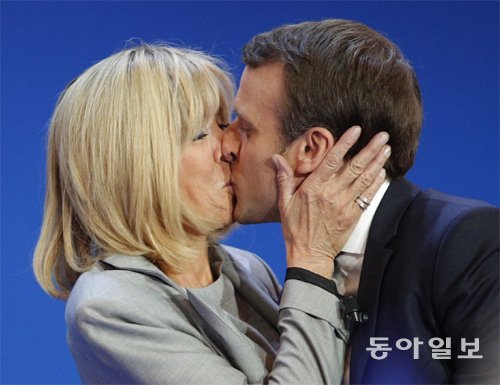 지난해 4월 프랑스 대선 1차 투표에서 1위를 차지한 에마뉘엘 마크롱 대통령(당시 중도신당 ‘앙마르슈’ 후보)이 부인인 브리지트 여사와 키스를 하고 있다. 동아일보DB