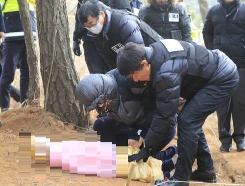 사진=4일 전북 군산시의 한 야산에서 친부 고 씨가 마네킹을 들고 구덩이에 파묻는 장면을 재현하고 있다(동아일보)