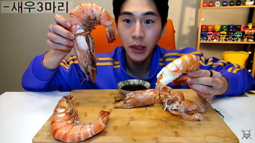 밴쯔가 블랙타이거 새우를 양손에 들어 얼굴 크기와 비교하고 있다. 그는 영상의 제목처럼 ‘고작’ 새우 3마리를 먹었다. 사진출처｜유튜버 밴쯔 화면 캡처