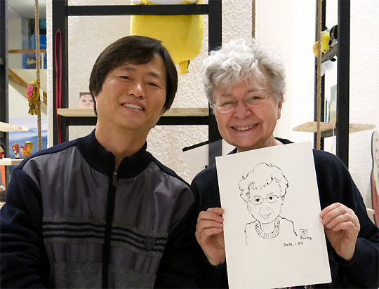 한 프랑스인이 24일 주프랑스 한국문화원에서 김평현 카툰 작가(왼쪽)가 그려준 자신의 캐리커처를 들고 즐거워하고 있다. 주프랑스 한국문화원 제공