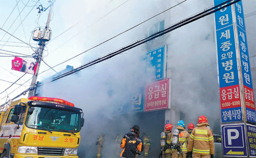 긴박했던 순간 26일 경남 밀양시 세종병원 앞에서 소방대원들이 불을 끄기 위해 다급히 움직이고 있다. 
시야를 가린 연기와 거센 불길로 소방대원들은 초기 진화에 애를 먹었다. 불은 신고 접수 약 3시간 만인 오전 10시 26분경 
완전히 진압됐다. 경남신문 제공