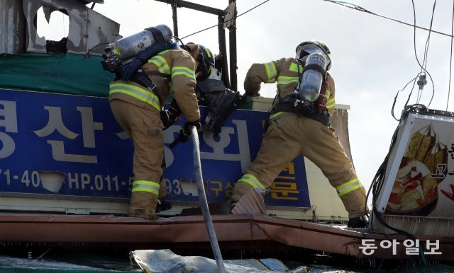 소방대원들이 남아있는 불씨를 찾기 위해 위험을 감수하고 낡은 천장위로 올라가 잔불 제거 작업을 하고 있다. 최혁중 기자 sajinman@donga.com