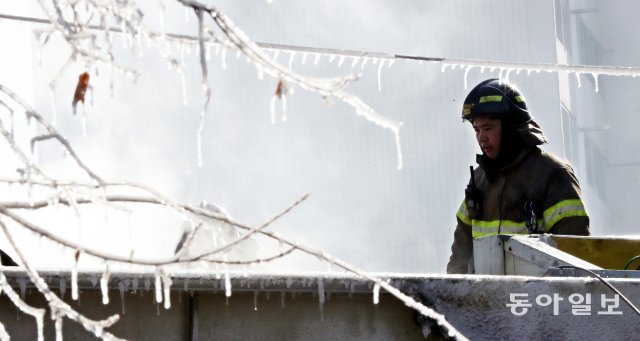 화재가 진압 된 후 잠시 휴식을 취하는 소방대원. 고지대 상고대를 연상 시킬 정도로 혹한의 날씨에 소방용수로 만들어진 나뭇가지의 고드름 사이로 소방대원이 지나가고 있다. 최혁중 기자 sajinman@donga.com