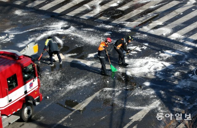 화재 진압 후 대원들이 언 도로와 소방으로 인해 발생한 쓰레기를 청소하고 있다. 최혁중 기자 sajinman@donga.com