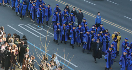 시민들의 축하를 받으며 행진하고 있는 졸업생들.