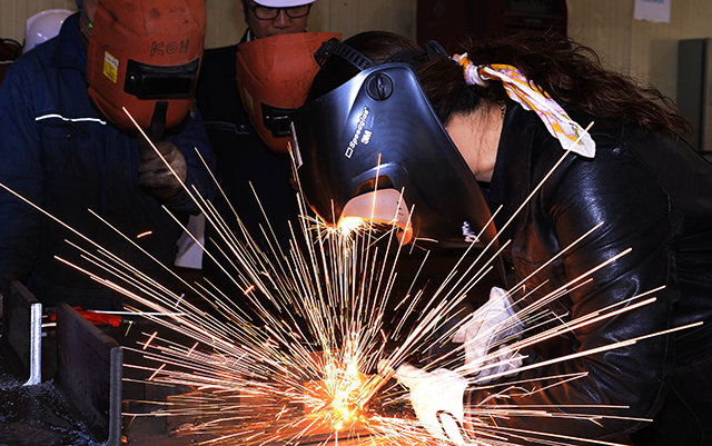 박은혜 씨(오른쪽)가 국내 한 중소기업의 대표와 직원 앞에서 용접면을 쓰고 용접 시범을 보이고 있다. 한국폴리텍대 제공