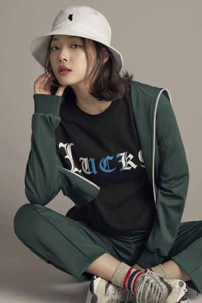 럭키슈에뜨의 ‘버킷햇+티셔츠 세트’를 소개하고 있는 모델 설리. 패션업계가 온라인 전용 상품을 늘리고 있다. 사진제공｜코오롱FnC