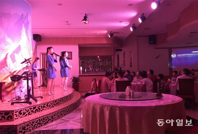 12일(현지 시간) 아랍에미리트 아부다비의 그랜드밀레니엄 알와다 호텔 2층에 입점한 북한 식당 ‘옥류관’에서 북한 여종업원들이 손님들 앞에서 공연하고 있다. 아부다비=박민우 특파원 minwoo@donga.com