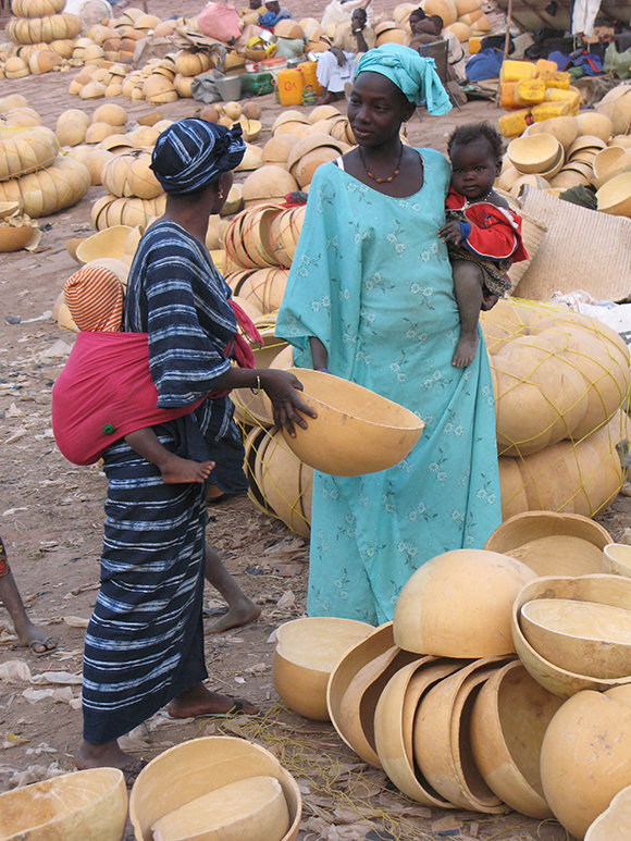아프리카 가나의 노천시장에서 박을 파는 여인.