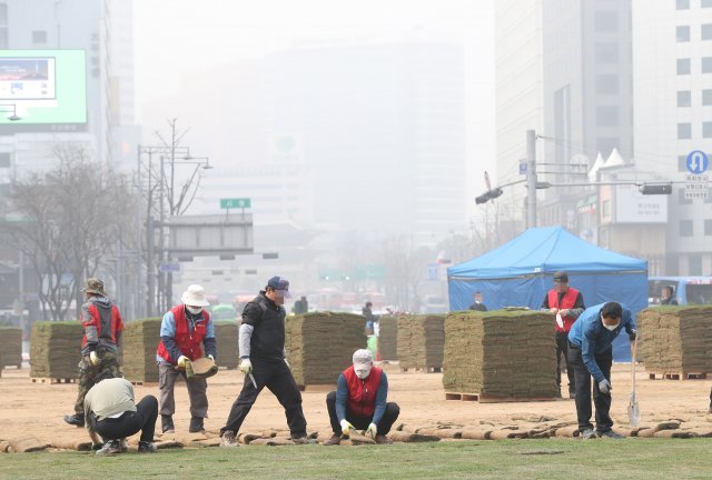 26일 오전 서울 숭례문이 미세먼지와 안개로 뿌연 가운데 인부들이 시청광장에서 잔디식재 작업을 하고있다.